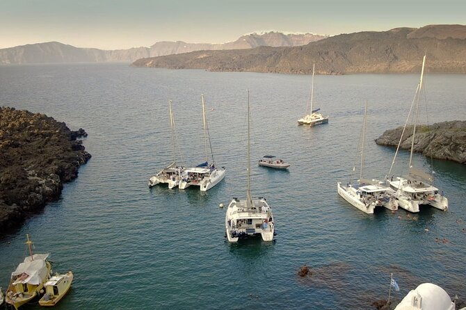 ALL-INCLUSIVE: Santorini Caldera Cruise with Greek Meal & Drinks - Lighthouse, caldera cliffs, and houses above the sea