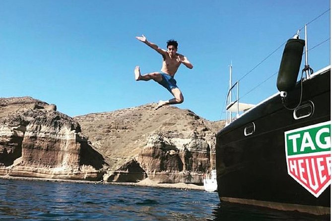 Santorini Adventurous Catamaran Experience with Snorkeling - Red Beach: dramatic cliffs and a flexible swim stop