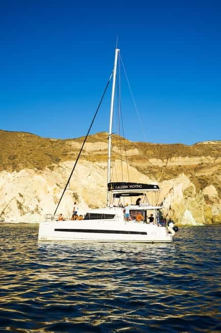 Santorini: Catamaran Cruise with Fresh Meal & Open Bar - Passing beneath Akrotiri Lighthouse