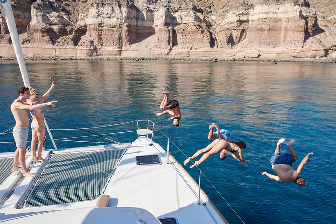 Santorini Gold Catamaran Cruise with BBQ, Drinks and Hotel Pickup - White Beach and the Akrotiri lighthouse
