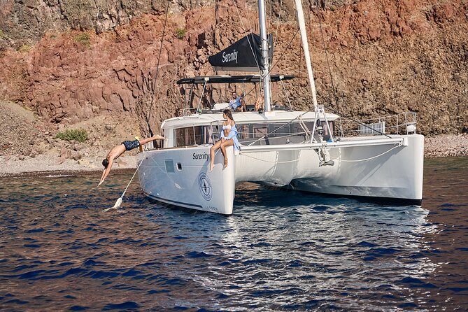 Santorini: Luxury Catamaran Cruise with Fresh Fish BBQ & Drinks - Mesa Pigadia, a black beach with clear water